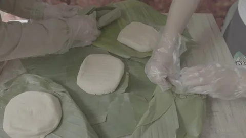 Workers wrapping cheese in large banana leaves Stock Footage 222015084