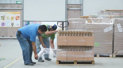 Workers wrapping package manually Stock Footage