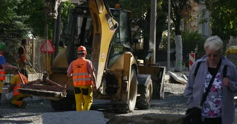 Workers in Yellow Workwear And Helmets Are Holding the Loader and Carrying it Stock Footage 54332545