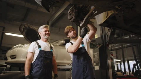 Workflow in a car workshop. Mechanic in work at the auto service. Family Stock Footage 243090973