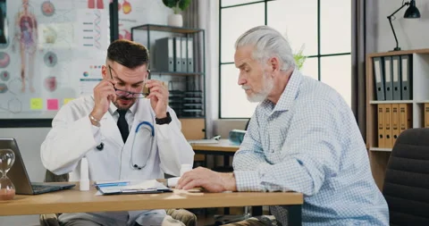 Workflow in clinic where attractive responsible qualified bearded doctor Stock Footage 160802562