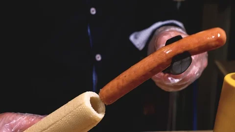 Workflow in a fast food cafe: a chef prepares a french hot dog with ketchup Stock Footage 112608706