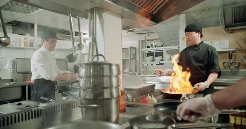 The workflow in the kitchen of the restaurant,a team of Asian chefs prepare Stock Footage