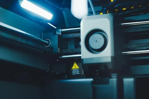 Working on 3D printer with laptop while preparing to print a project in a home Stock Photos