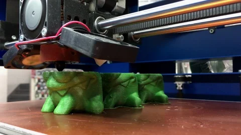 Working 3D Printer Printing Toys from Green Plastic with Additive Technology Stock Footage 101760818