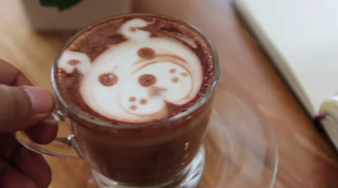Working and drinking  a cup of art latte at coffee shop, shape of a bear 스톡 동영상 50589467