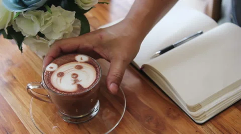 Working and drinking  a cup of chocolate at coffee shop, shape of a cute bear 스톡 동영상 50304957