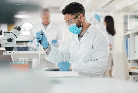 Working on another controlled experiment. a young scientist working with samples Stock Photos