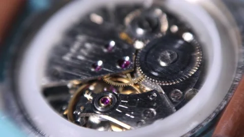 Working balance wheel, spring, and gears of a mechanical wind watch, closeup Stock Footage 165779878
