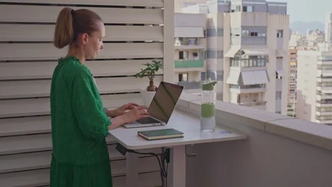 Working on a balcony with a laptop while enjoying the view of the city skyline Stock Footage 338166891