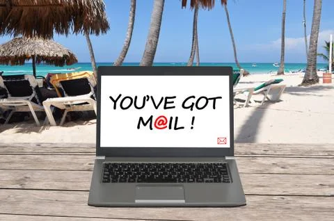 Working from the beach office with notebook receiving email Fotos Stock
