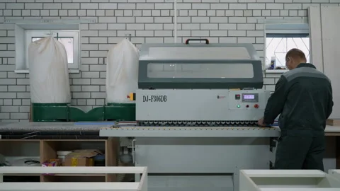 Working behind a machine that applies an edge to a wooden part Stock Footage 219730670