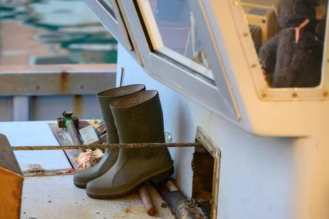 Working boots on a boat deck. Stock Photos