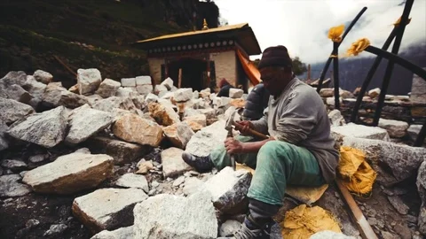 Working brick layer in Namche Bazaar, Nepal. The Himalaya are on the background Stock Footage 72950342