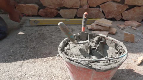 Working bucket with cement solution, spatula and trowel on construction site Stock Footage 164051924
