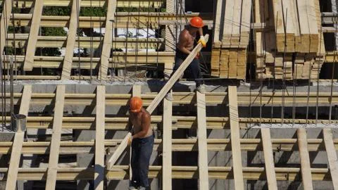 Working builders at a high-rise building site Stock Photos