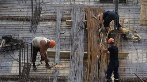 Working builders at a high-rise building site Stock Photos