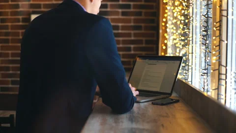Working from cafe. Cheerful young man in smart casual wear looking at laptop and Stock Footage 85899824