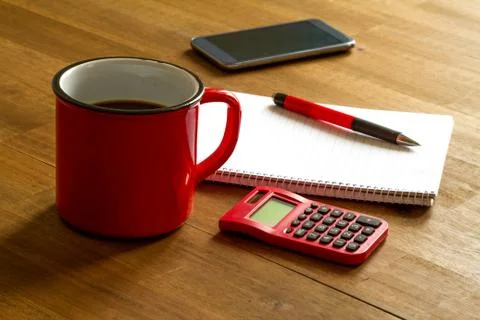 Working with the calculator and taking notes meanwhile drinking a cup of coffee Stock Photos