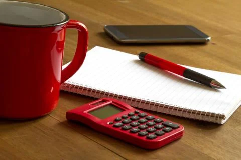 Working with the calculator and taking notes meanwhile drinking a cup of coffee Stock Photos