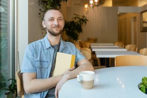 Working at a coffee shop while studying online in a cozy workspace Stock-Fotos