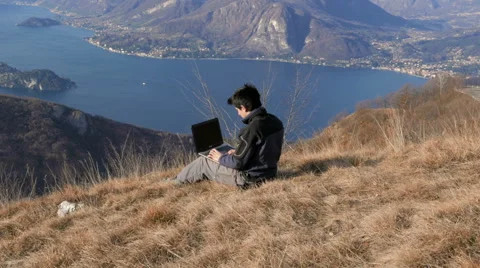 Working with the computer in front of a beautiful landscape Stock Footage 59719049