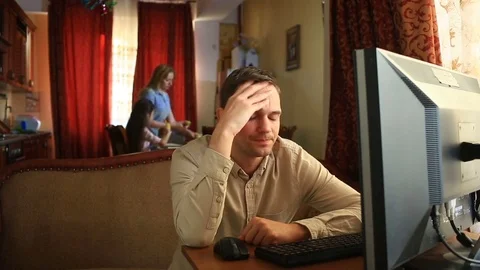Working on the computer at home, her husband is disappointed with the failure of Stock Footage 75360046