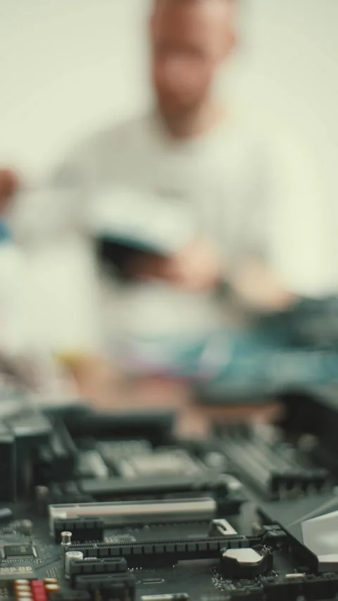Working on a computer motherboard in a workshop with tools and parts spread out Stock Footage 348317459