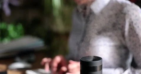 Working on computer next to aroma oil diffuser on table Stock Footage 232215179