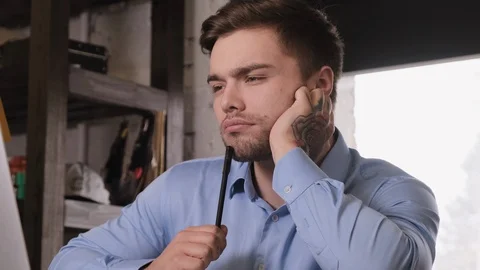 Working on the computer young bearded man in a stylish look has a great idea Stock Footage 104134498