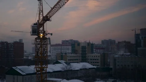 Working in the construction crane at a construction site at dusk in winter, 4k Stock Footage 71520401