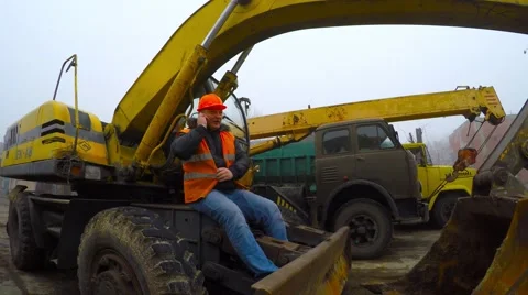 Working in the construction helmet talking on the phone to mobile cranes. 库存影片 57297873