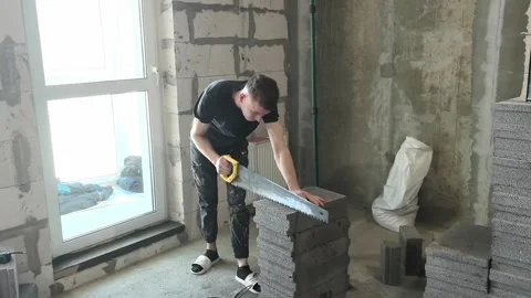 Working on construction in a new building in an unfinished room with grey blocks Stock-Footage 332148508