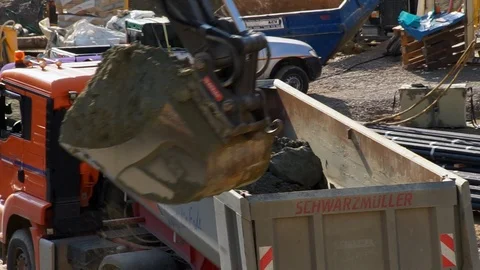 Working at a construction site, a excavator lifting up soil Stock Footage 88649594