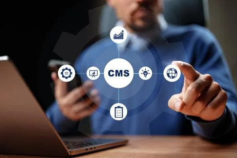 Working with a content management system on a laptop while using a smartphone Stock Photos