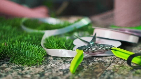 Working counter of a florist, scissors, ribbon and fir branch. Stock-Footage 101498523