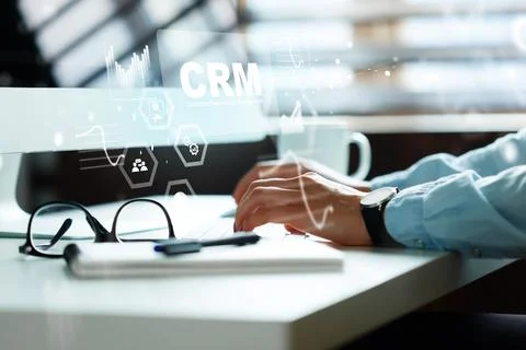 Working on CRM software at a desk with a computer and a cup of coffee Stock Photos