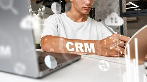 Working on CRM strategies using a laptop and notepad in an office setting Stock Photos