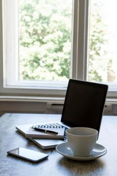 Working with a cup of coffee close to the window Stock Photos