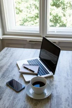 Working with a cup of coffee close to the window Stock Photos
