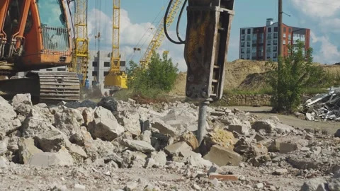 Working day at construction site. Excavator with hydraulic hammer crushes old Stock Footage 314060351