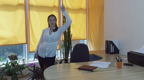 Working day. Pretty young brown-haired woman dancing at the desk in a office. HD Stock-Footage 68584681