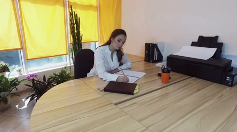 Working day. Pretty young brown-haired woman dancing at the desk in a office. 4K Stockbeeldmateriaal 68647203