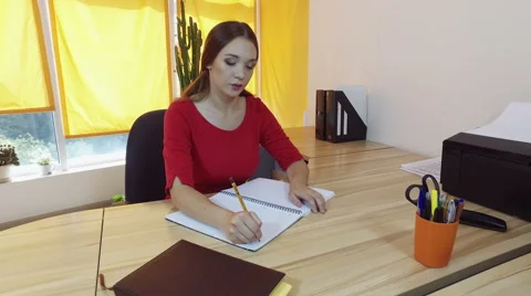 Working day. Pretty young brown-haired woman dancing at the desk in a office. 4K Video stock 68648608