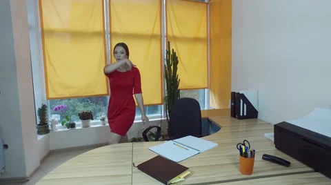 Working day. Pretty young brown-haired woman dancing at the desk in a office. 4K Vidéo 68649159