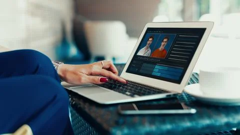 Working on deep fake technology in a coffee shop setting with a laptop and user Stock Photos