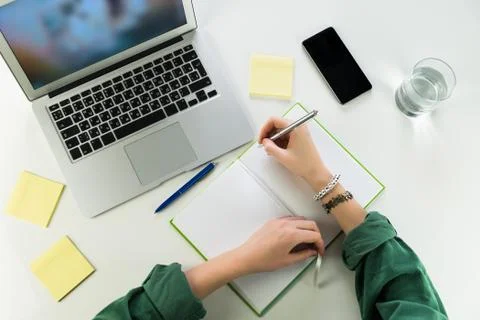 Working at desk with notepad and laptop computer Stock Photos