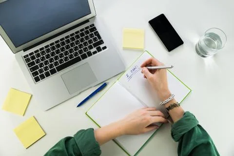 Working at desk with notepad and laptop computer Stock Photos