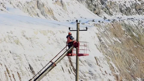 A working electrician does his job while on a car lift Stock Footage 124192598
