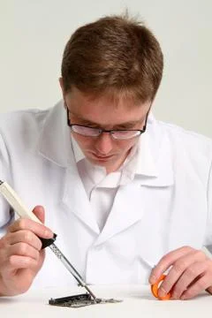 Working electronics repairing board using soldering pen Stock Photos